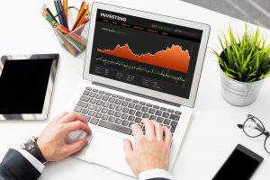 Businessman reviewing stock charts on laptop